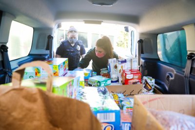 Police Officer and Zookeeper loading food into van