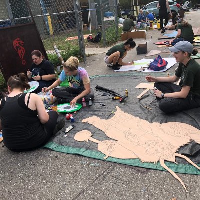 group of people painting cardboard decorations
