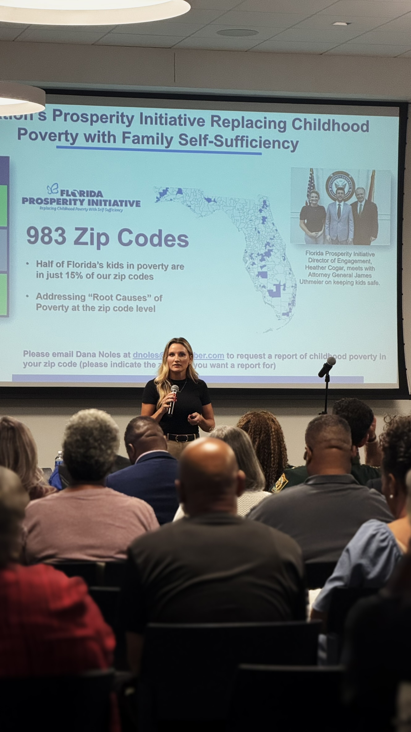 Speaker with data slide behind her