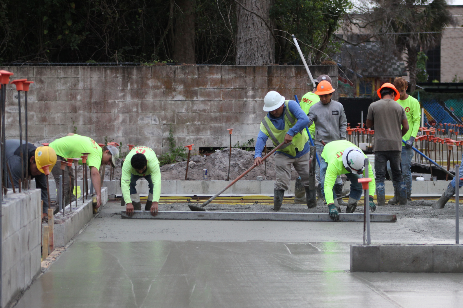 Crews smooth freshly poured cement